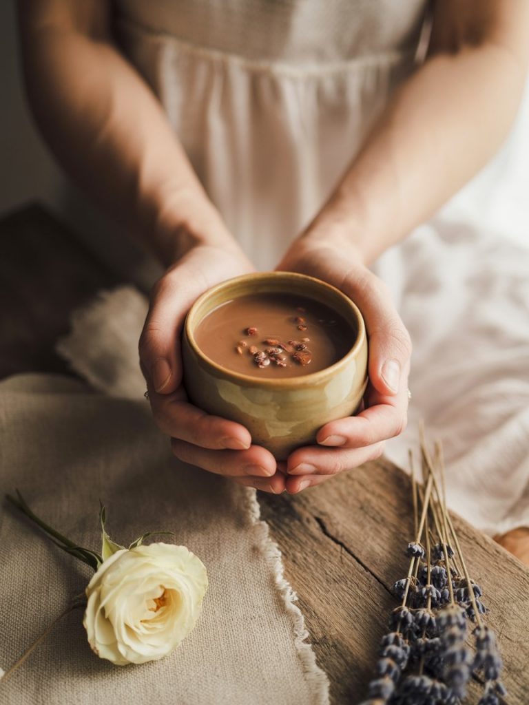 Frau hält zeremoniellen Kakao in Händen